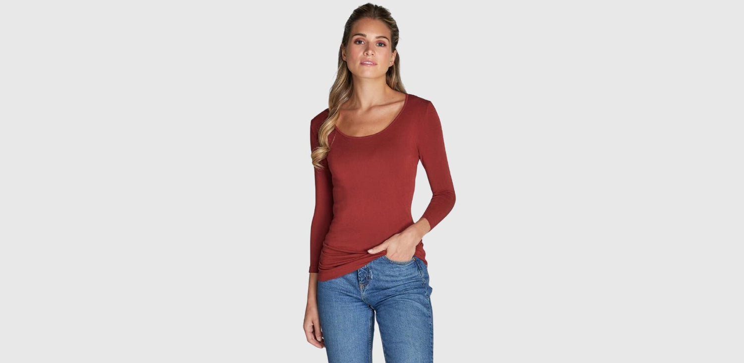 A woman wears a body-fitting T-shirt with a scoop neck and 3/4 sleeves