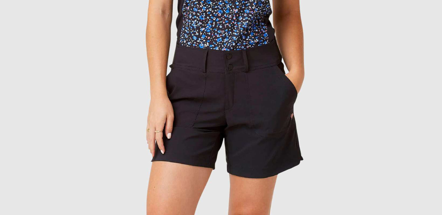 A woman is shown wearing dark denim cutoff shorts.