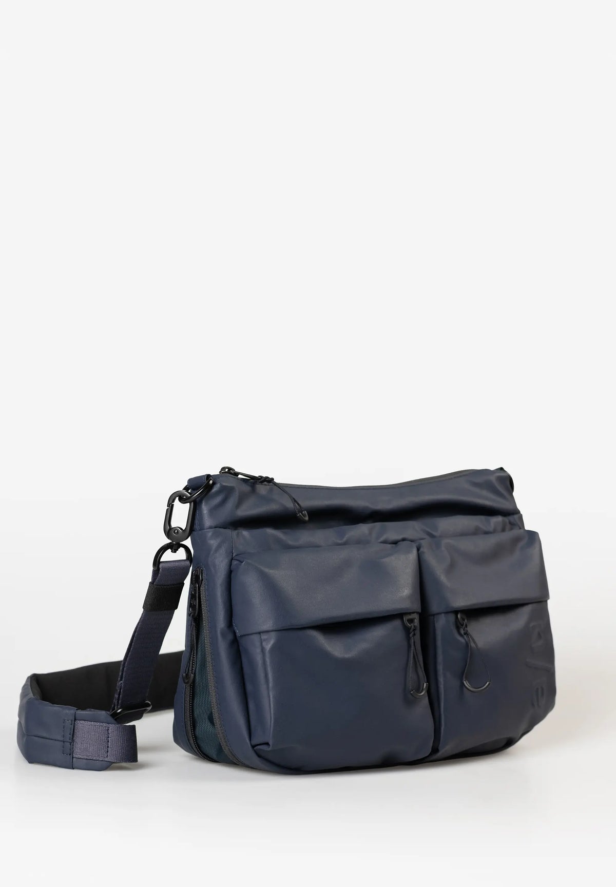 Aunts & Uncles Mogami RE Lite Crossbody Bag. A navy blue nylon messenger bag with a front flap pocket, zippered compartments, and an adjustable shoulder strap, shown on a clean white background.