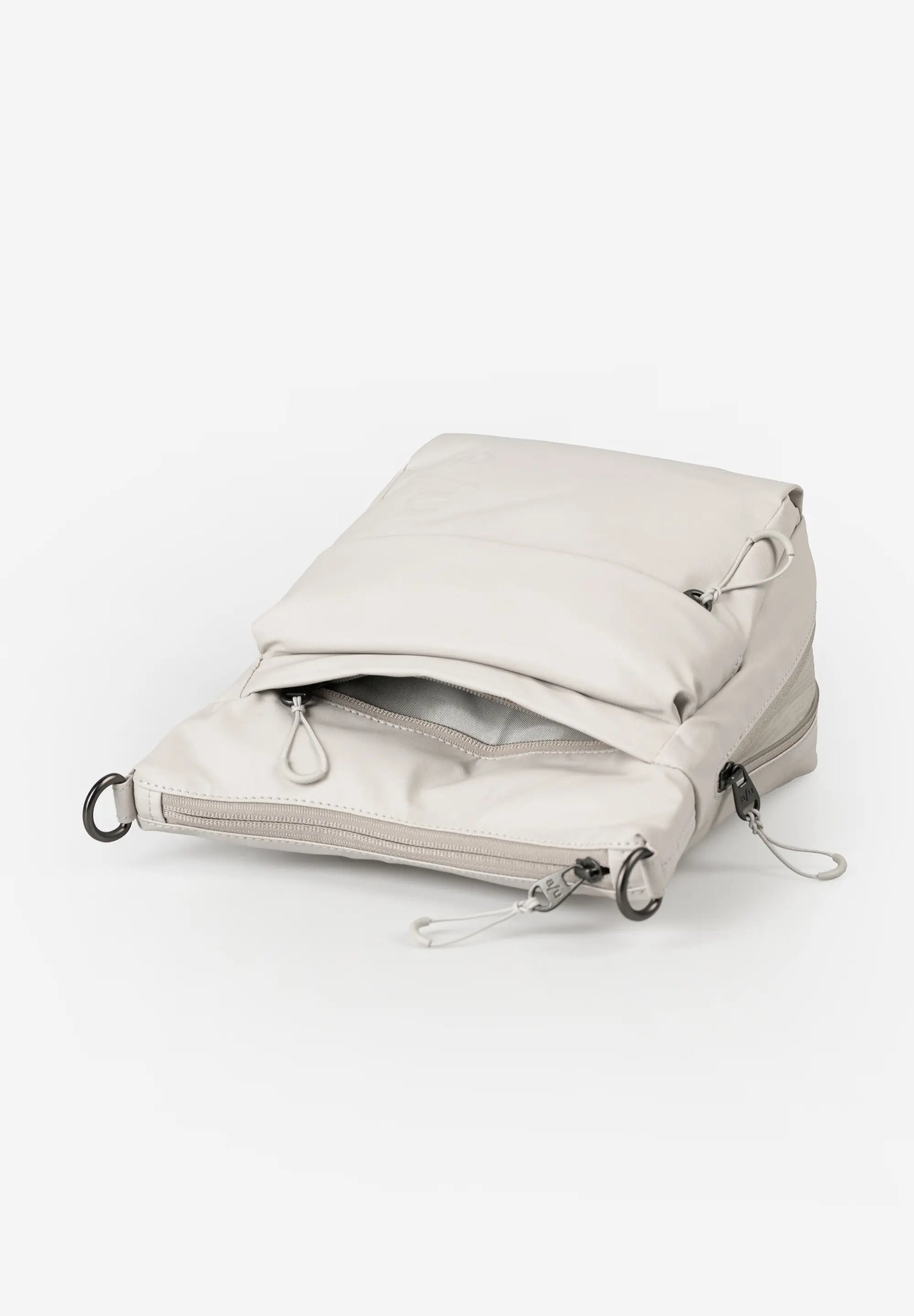 Aunts & Uncles Yura RE Lite Crossbody Bag. Light gray backpack on a white background