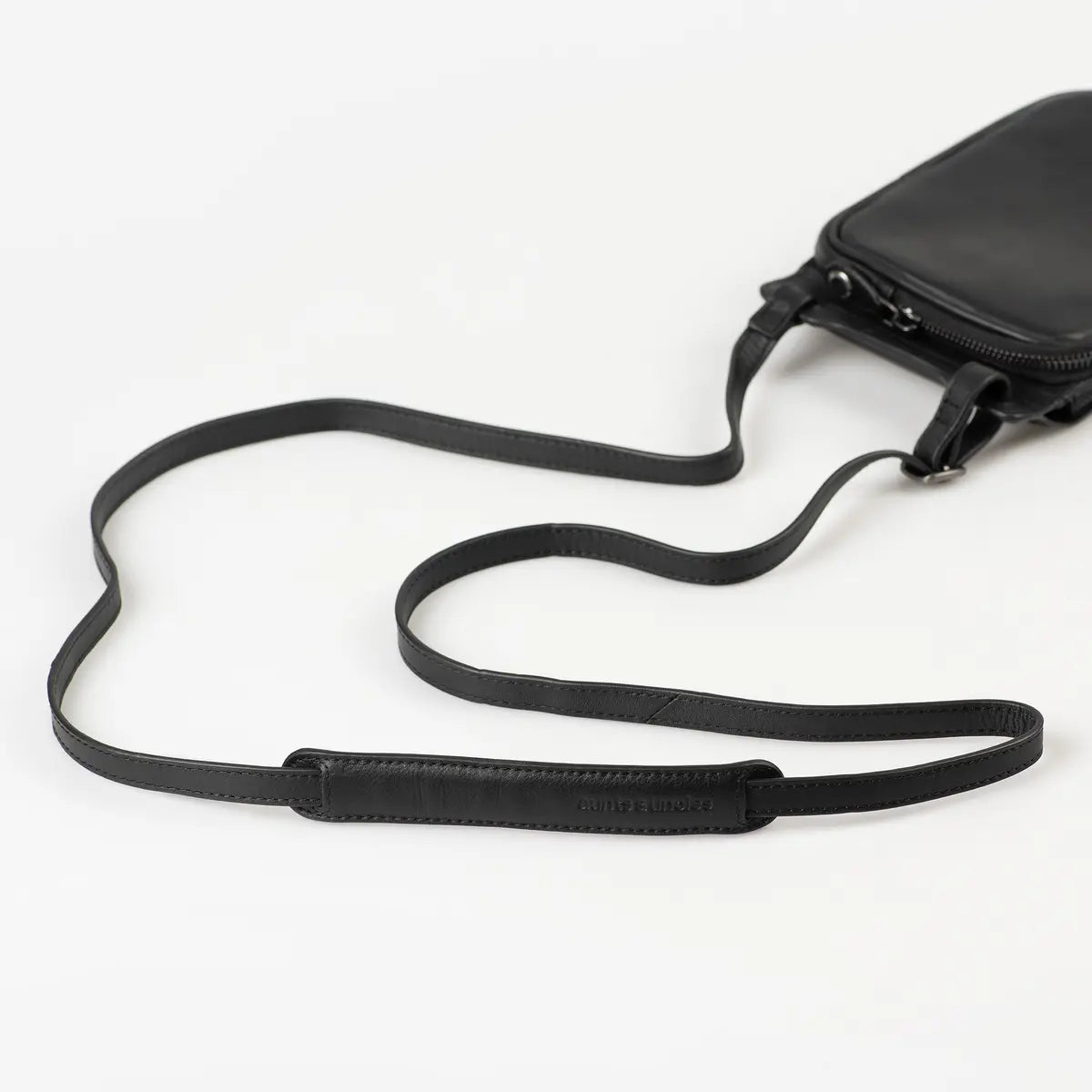 Aunts & Uncles Tulip Leather Phonebag Wallet. A black leather crossbody bag with a matching adjustable shoulder strap, shown on a clean white background.