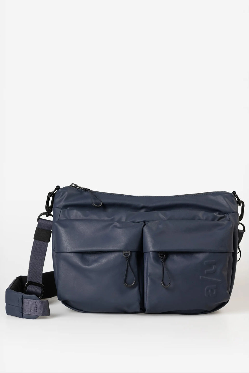 Aunts & Uncles Mogami RE Lite Crossbody Bag. A navy blue nylon messenger bag with multiple front zippered pockets and an adjustable shoulder strap, displayed on a clean white background.