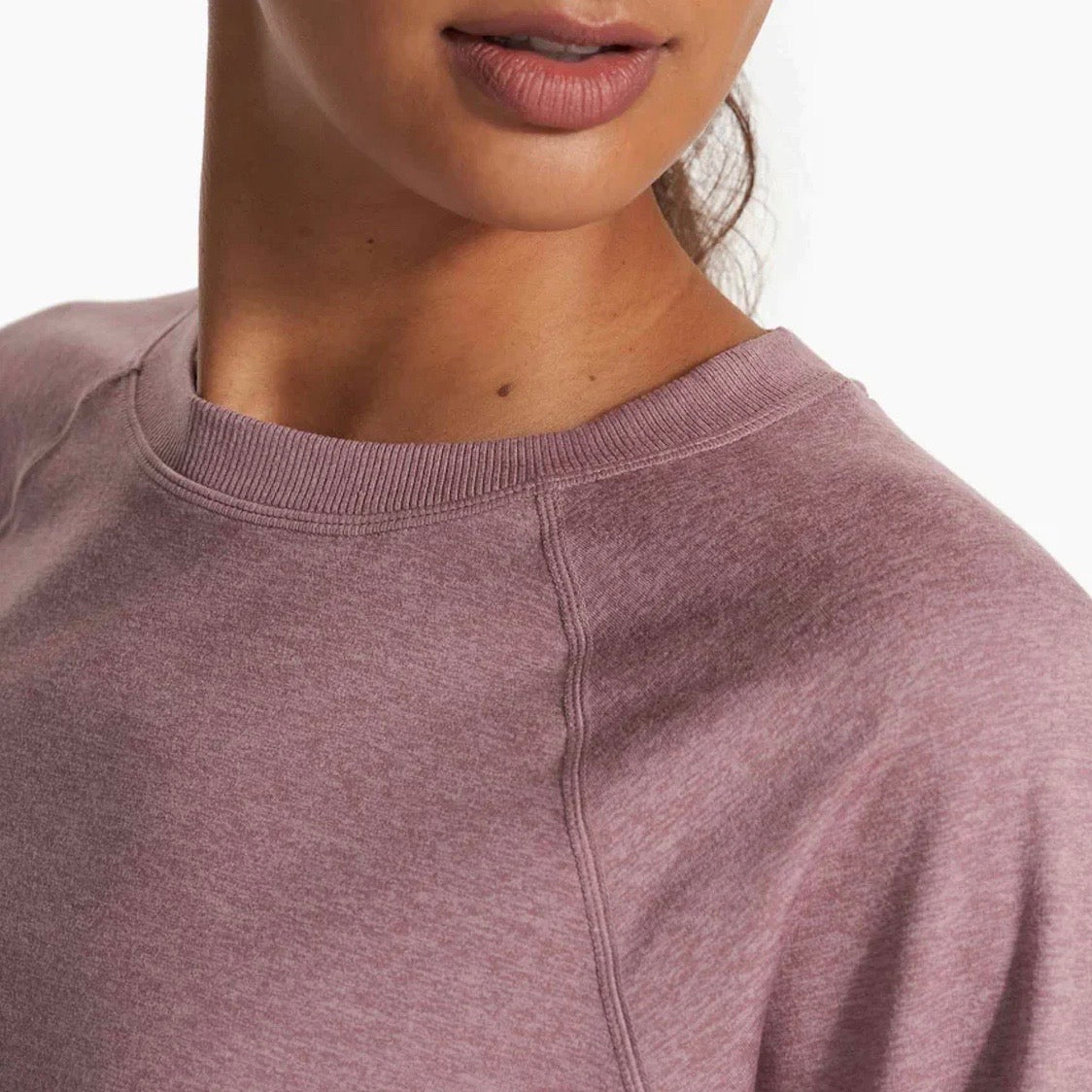 A woman is shown wearing a mauve top