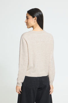 Ichi Fanita Cardigan. A woman shown from the back wearing a light beige knit sweater and dark wide-leg pants against a plain light gray studio background.