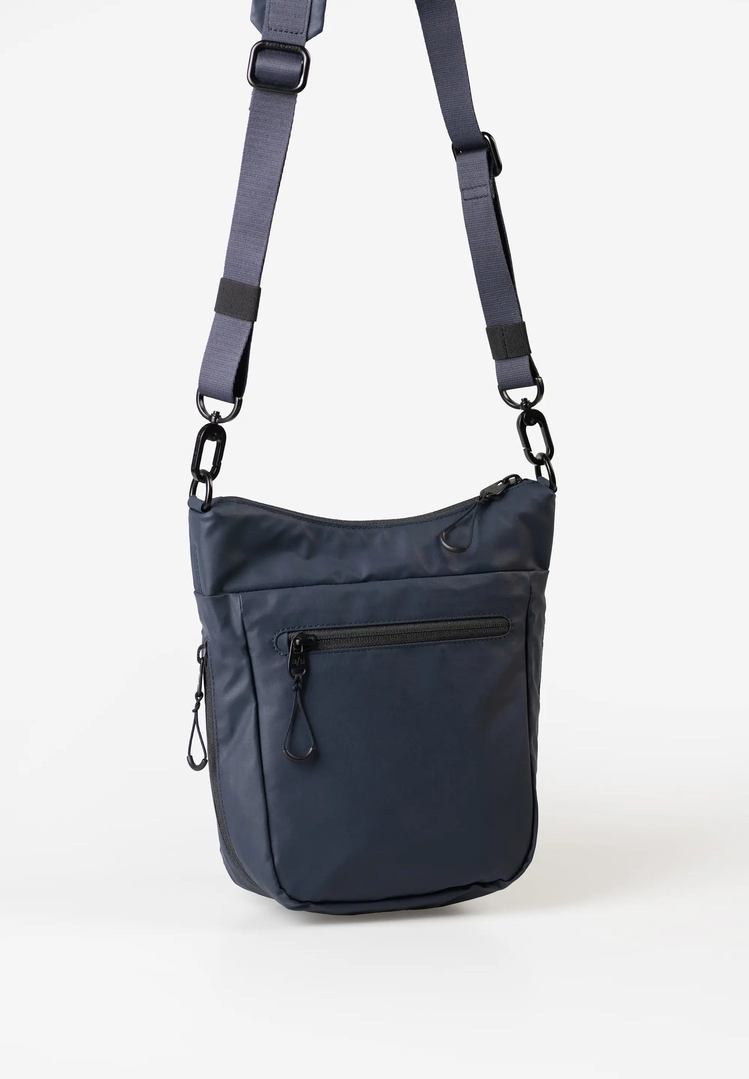 Aunts & Uncles Yura RE Lite Crossbody Bag. A navy blue nylon shoulder bag with an adjustable shoulder strap, a front zippered pocket, and a main zippered compartment, shown against a plain white background.