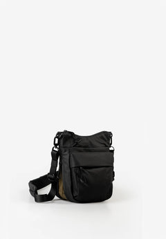 Aunts & Uncles Yura RE Lite Crossbody Bag.A black nylon shoulder bag with a front zippered pocket and an adjustable shoulder strap, photographed on a seamless white studio background.