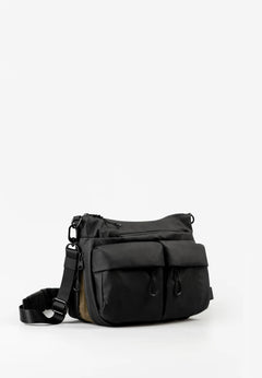 Aunts & Uncles Mogami RE Lite Crossbody Bag. A black nylon messenger bag with multiple front pockets and an adjustable shoulder strap, photographed on a clean white studio background.