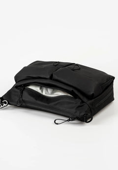 Aunts & Uncles Mogami RE Lite Crossbody Bag. A black nylon utility pouch or small bag with a zippered opening, shown open on a clean white studio background.