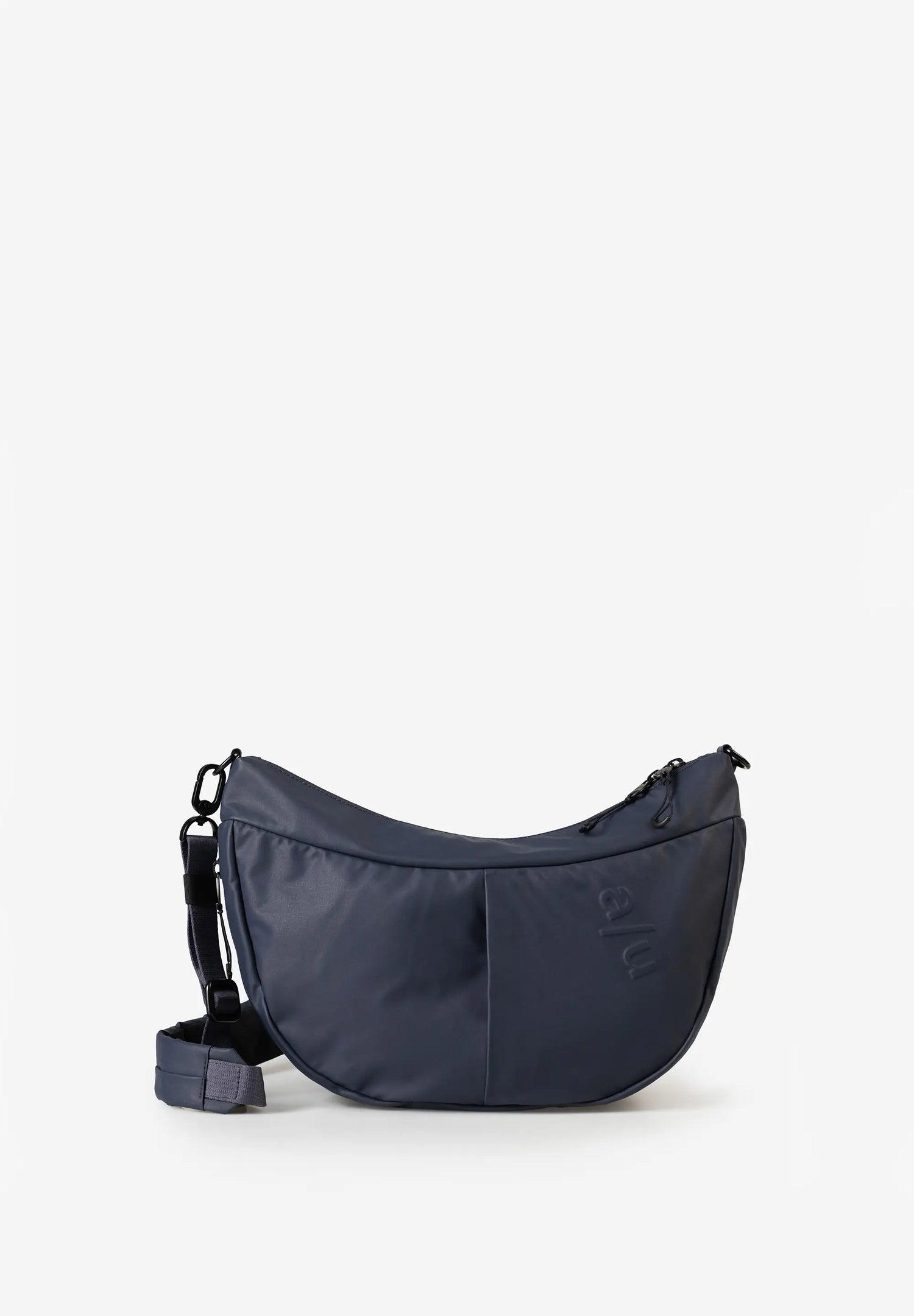Aunts & Uncles Toyo RE Lite Halfmoon Bag. A navy blue crescent-shaped crossbody bag with a matching detachable strap, displayed on a clean white background.