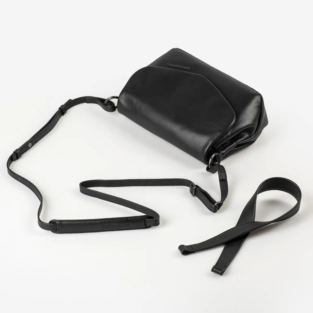 Aunts & Uncles Fern Leather Crossbody Purse. A black leather crossbody bag with a long adjustable strap, displayed on a clean white background.
