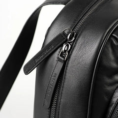 Aunts & Uncles Coco Leather Backpack Purse.  Close-up of a black leather backpack showing a zipper with a branded pull tab that reads 'TWEEL STUDIOS'.