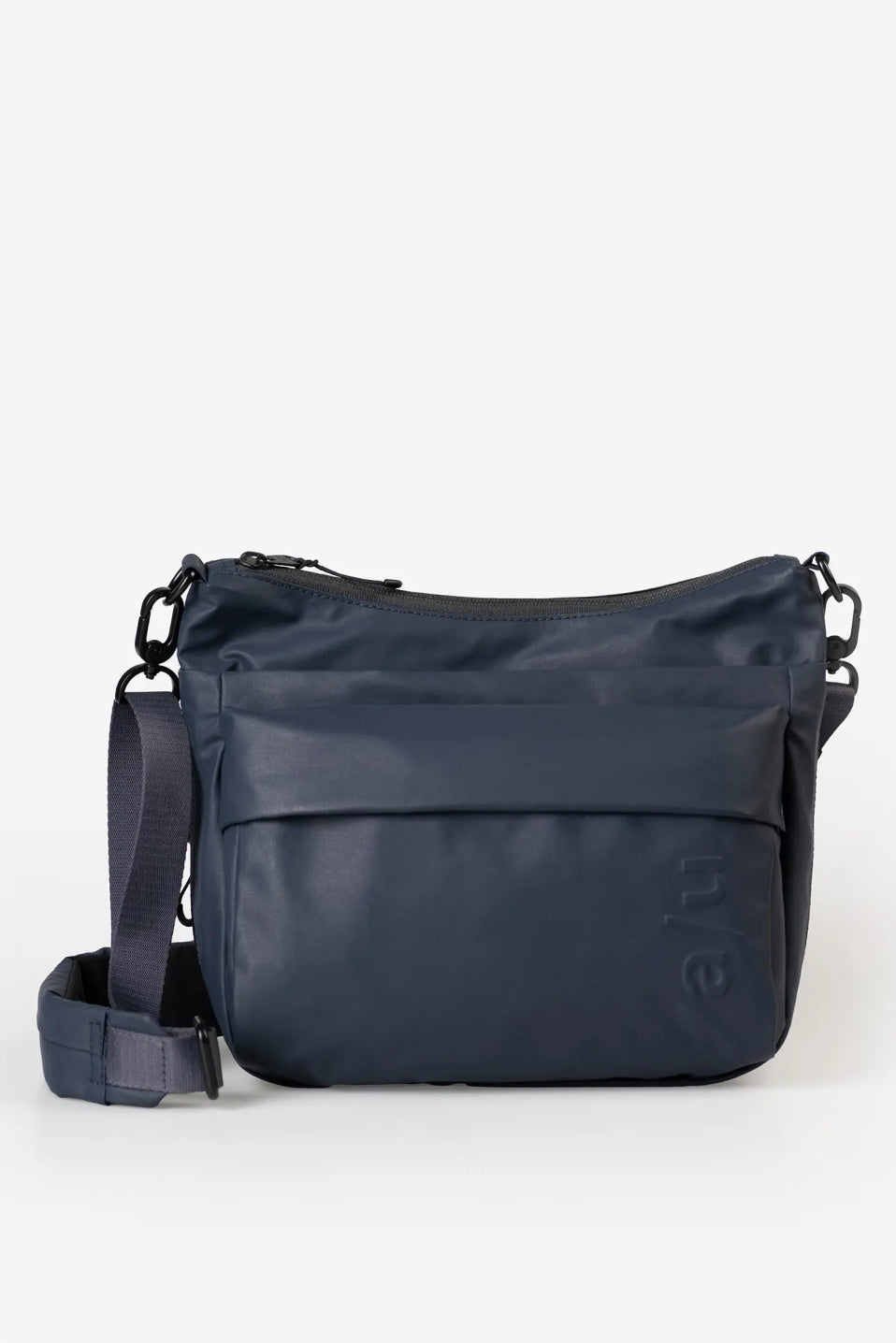 Aunts & Uncles Nanuki RE Lite Crossbody Bag. A navy blue nylon messenger bag with a front slip pocket, adjustable shoulder strap, and a subtle embossed logo, shown against a plain white background.
