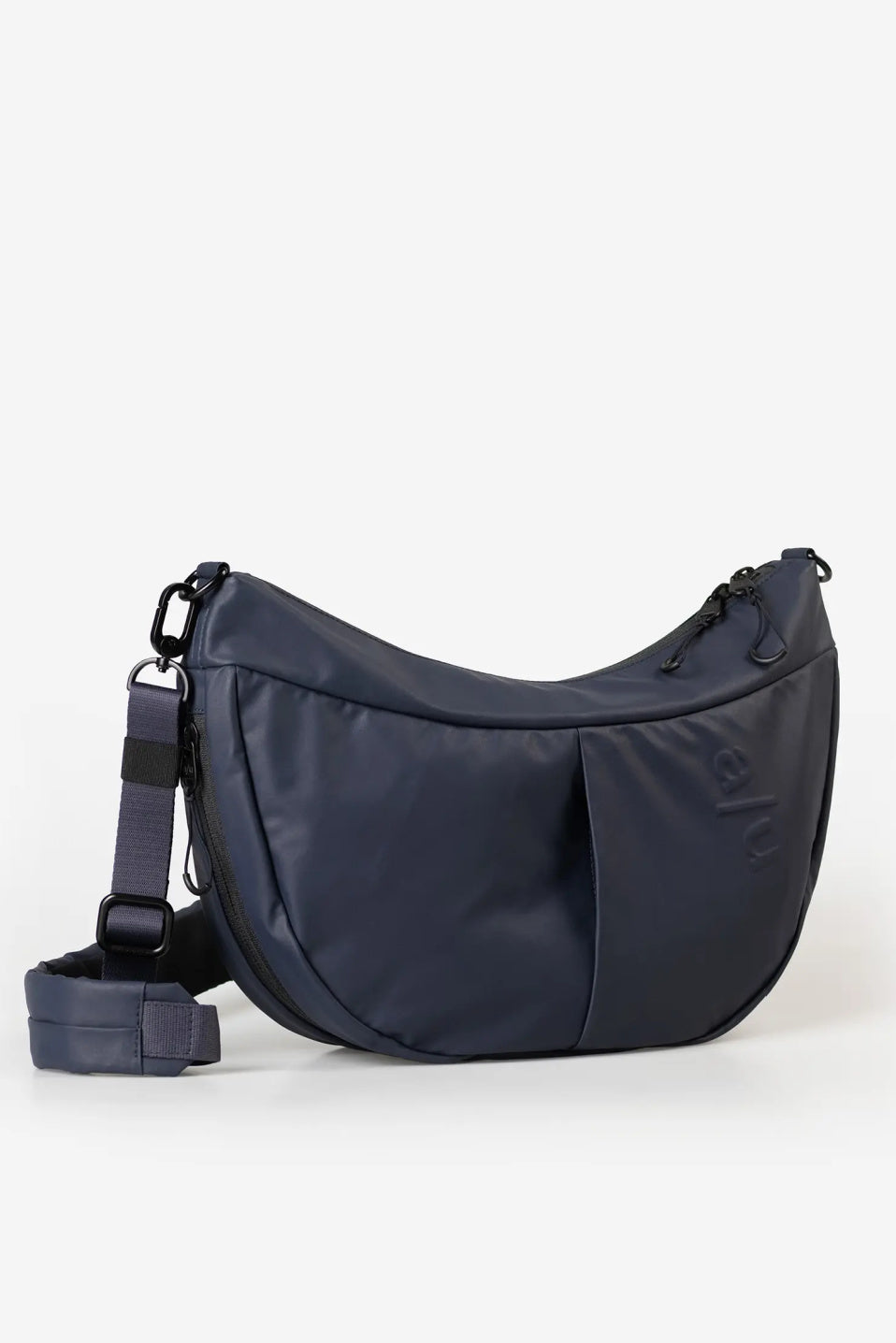 Aunts & Uncles Toyo RE Lite Halfmoon Bag. A navy blue crescent-shaped shoulder bag with a matching detachable strap, displayed on a clean white background.